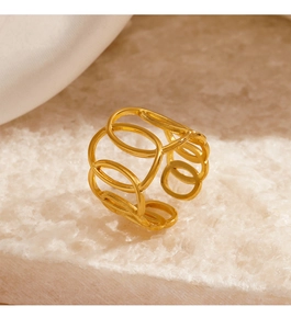 Detail of gold geometric hollow chain ring placed on a textured white mineral stone base