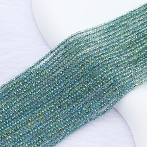 Macro detail of 2mm faceted crystal beads with vibrant blue-green AB electroplated finish