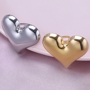 Detailed close-up of gold and silver heart rings on a pink ceramic plate