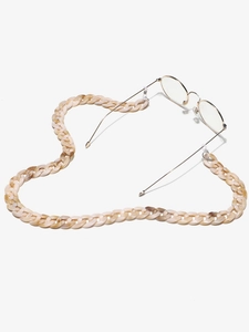 Detail of amber acrylic glasses chain arranged in a heart shape on a white background
