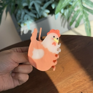 Détail de la pince à cheveux poussin en acétate rose corail avec finition polie et 3D