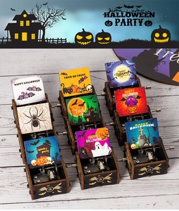 Macro shot of mechanical hand-cranked wooden music box with Halloween illustrations