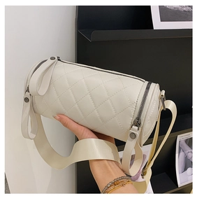 Detail of quilted leather cylinder bag in cream white with stylish wide shoulder strap