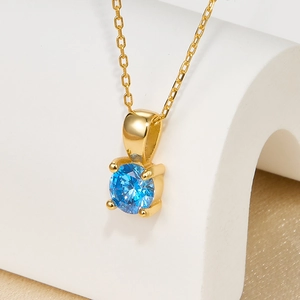 Detail of blue birthstone pendant in 925 silver with gold plating and fine O-chain link