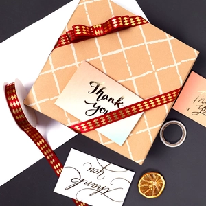Gold diamond pattern ribbon with Thank You card on kraft paper gift box