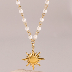 Collana di perle con ciondolo a sole dorato e catena in acciaio su base in pietra