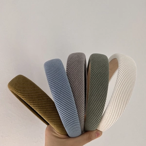 Close-up of five knitted twill headbands in olive, blue, grey, green, and beige colors