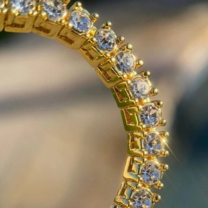 Macro shot of gold tennis bracelet featuring sparkling round-cut moissanite stones