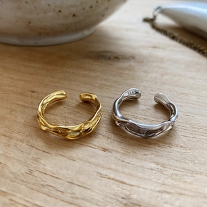 Detailed view of S925 sterling silver rings with irregular hammered texture on wood