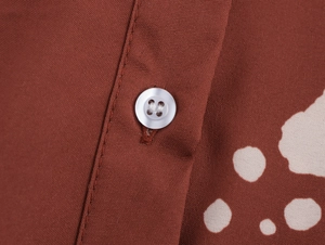 Détail du tissu à imprimé floral marron avec un bouton blanc et couture soignée