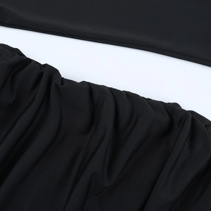 Detaillierte Nahaufnahme des schwarzen gerafften Strickstoffs vom eng anliegenden Kleid