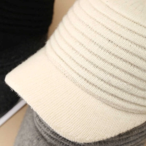 Close-up of ribbed knit texture on cream white winter cap with soft fabric detail