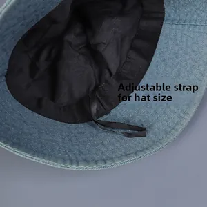 Detail of adjustable inner drawstring and black lining on blue denim bucket hat