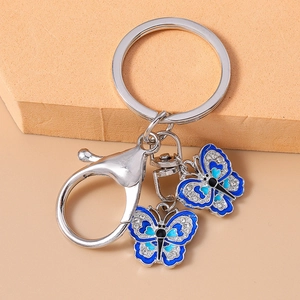 Close-up of butterfly keychain with blue enamel pendants and sparkling rhinestones