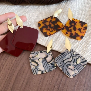 Detail view of geometric square drop earrings in dark red, tortoiseshell, and marble patterns