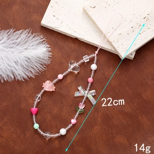 Pink and clear beaded phone charm with heart bow and tulip motifs on brown texture