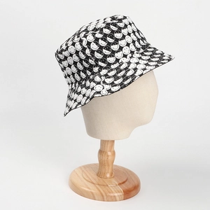 Détail d'un chapeau bob en coton noir et blanc avec un imprimé smiley intégral de mode