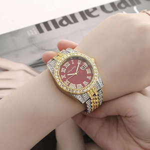 Close-up of luxury women's watch with red dial, rhinestones and two-tone metal strap
