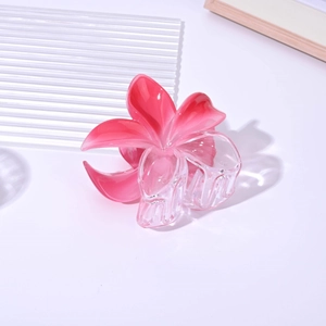 Detail of 8cm large translucent pink gradient frangipani flower hair claw clip on book