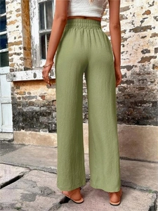 Détail du dos du pantalon large vert montrant la taille haute élastique et le tissu plissé