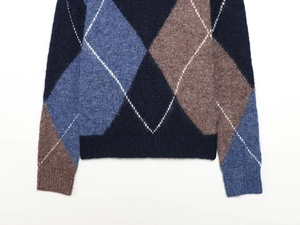Detailed view of the argyle knit texture with ribbed hem and cuffs on this cozy sweater