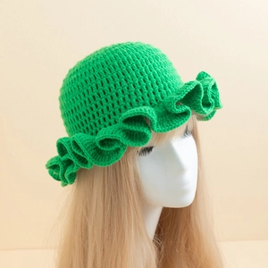 Detailed knit texture and ruffled brim of a handmade crochet grass green bucket hat