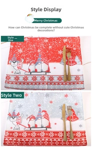 Detail of Christmas placemats with Santa patterns and golden cutlery on marble surface