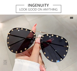 Macro shot of aviator sunglasses featuring gold metal studs and slim double bridge frame