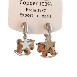 Retro rocking horse earrings with star detail and silver copper frame on white background