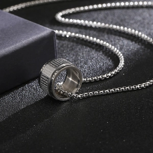 Macro shot of silver rotating spinning ring necklace with Heart Sutra script engraving
