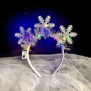 Detail of LED light-up Christmas headband with silver glitter snowflakes and tinsel
