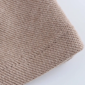 Detailed macro view of camel knit fabric with soft ribbed texture and seamless stitching