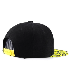 Detail of adjustable snap closure and yellow graffiti print on black hip hop snapback cap