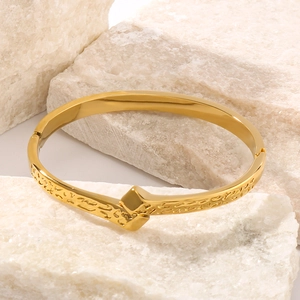 Golden geometric rock texture stainless steel cuff bangle with diamond-shaped centerpiece