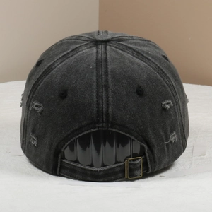 Detail of distressed black denim baseball cap with metal buckle and vintage wash texture