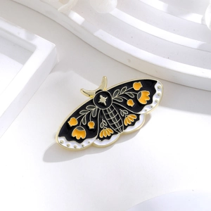 Detail of moth enamel brooch with floral pattern and star motif on geometric stand