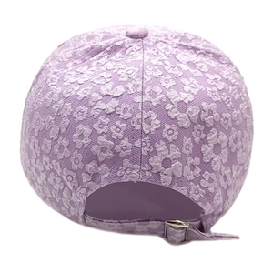 Close-up of lavender floral jacquard fabric and silver metal buckle on baseball cap
