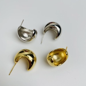Detailed macro view of 18K gold and silver plated C-shaped curved stud earrings