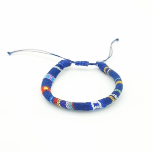 Detail of colorful Bohemian hand-woven cotton thread bracelet with ethnic patterns
