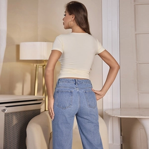 T-shirt ajusté crème à col en V en maille côtelée porté avec un jean bleu évasé