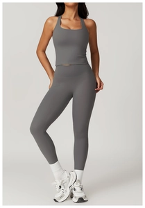 Detail of high-waist grey yoga leggings and U-neck sports bra on a fitness model