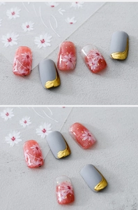 Close-up of matte grey nail stickers with gold lines and pink floral art designs