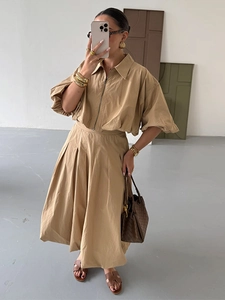 Détail d'un ensemble kaki style utilitaire avec chemise zippée et jupe plissée femme