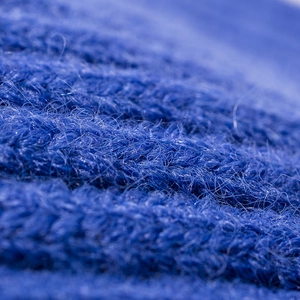 Vue macro de la texture de laine tricotée bleue douce pour un bonnet d'hiver chaud.