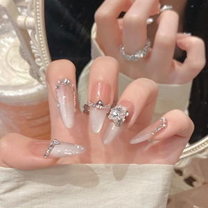Detail of luxury handmade cat-eye press-on nails with gradient nude finish and 3D bows