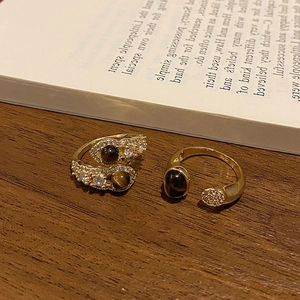 Dettaglio degli anelli placcati oro 18 carati con occhio di tigre su un libro e luce calda