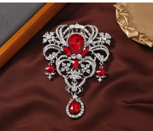 Close-up of vintage royal style brooch with red ruby stones and intricate crystals