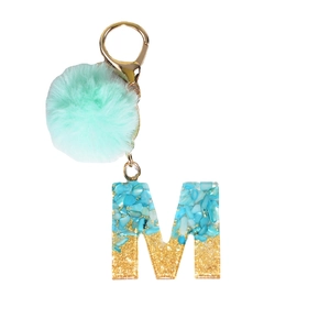 Light blue pompom keychain with gold letter M resin charm and blue crushed stones