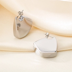Irregular fin shaped titanium steel stud earrings with polished silver geometric finish