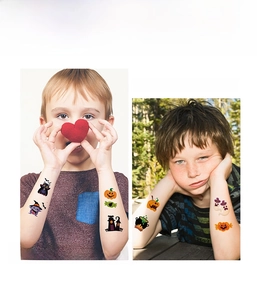 Detailed view of kids' arms with waterproof cute pumpkin and ghost Halloween tattoos